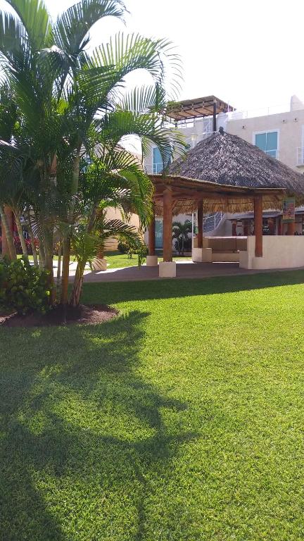 a gazebo with palm trees in a park at Departamento completo en Marina Diamante in Acapulco