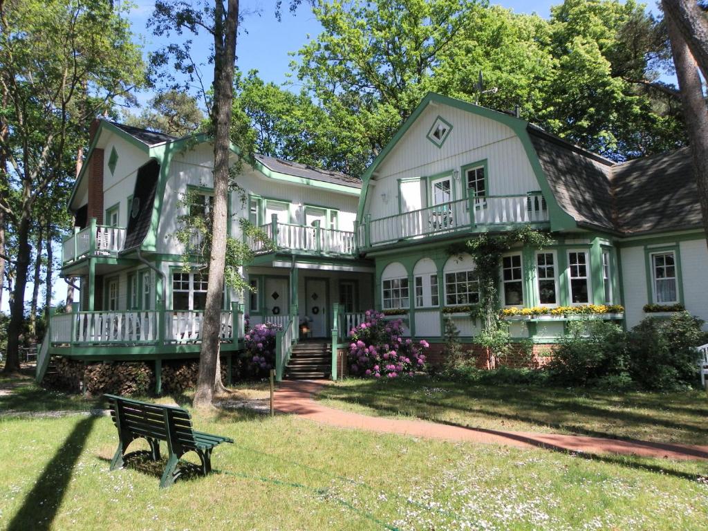 una casa verde con un banco delante en Landhaus Victoria, en Boltenhagen