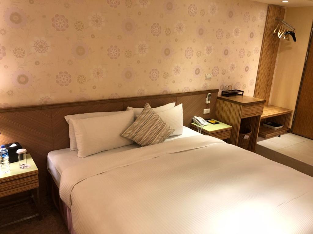 a bedroom with a large white bed with two tables at Homey House in Taipei