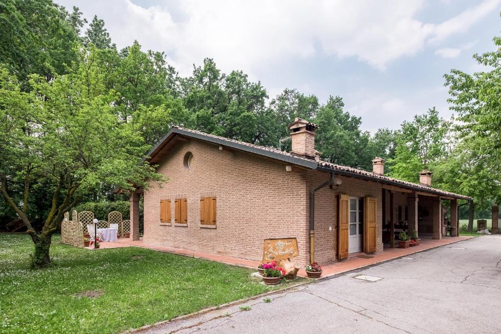 a brick house with a yard and a driveway at Mb bed & breakfast in Zola Predosa