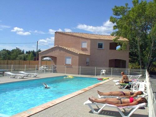 2 personas en las tumbonas de una piscina en les vignes, en Lablachère