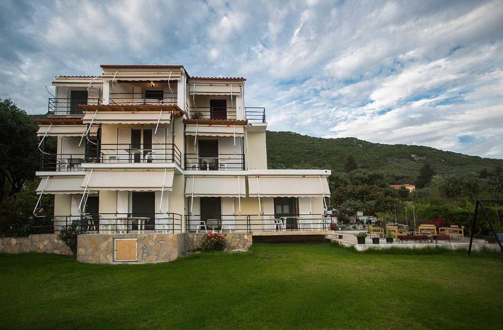 a large house with a green lawn in front of it at Areti Studios in Paramonas