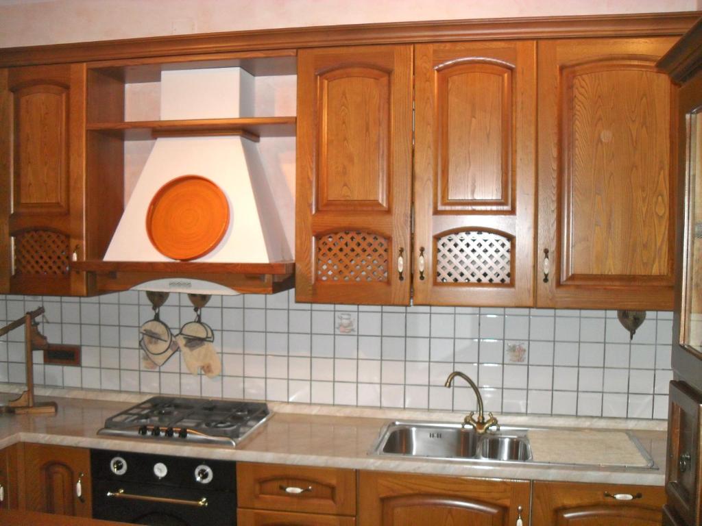 una cucina con armadi in legno e lavandino di Affittacamere Casa Sofia ad Anghiari