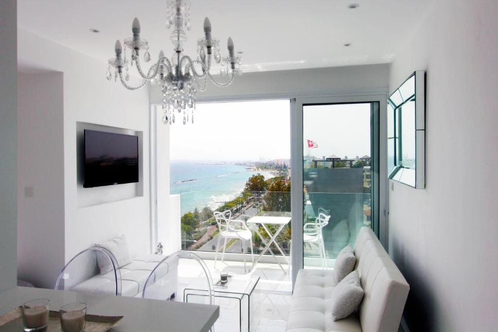 a living room with a chandelier and a living room with a view at The White Pearl Suite - beach front city centre with sea view. in Limassol