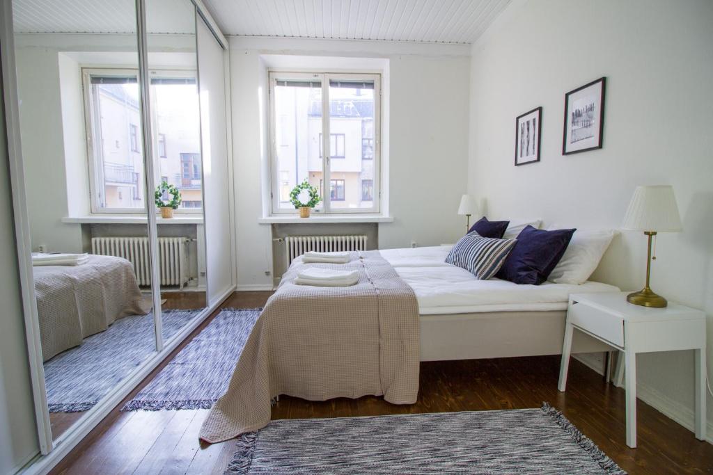 un soggiorno con divano bianco e 2 finestre di 2ndhomes Fabianinkatu Apartment a Helsinki