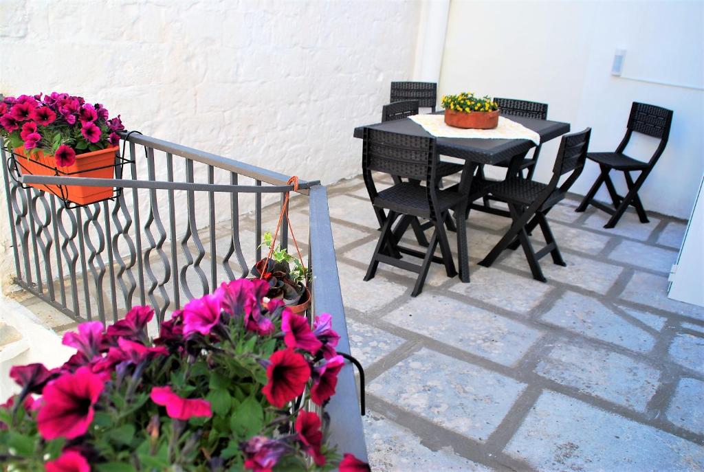 a patio with a table and chairs and flowers at Iannet & Co. in Locorotondo