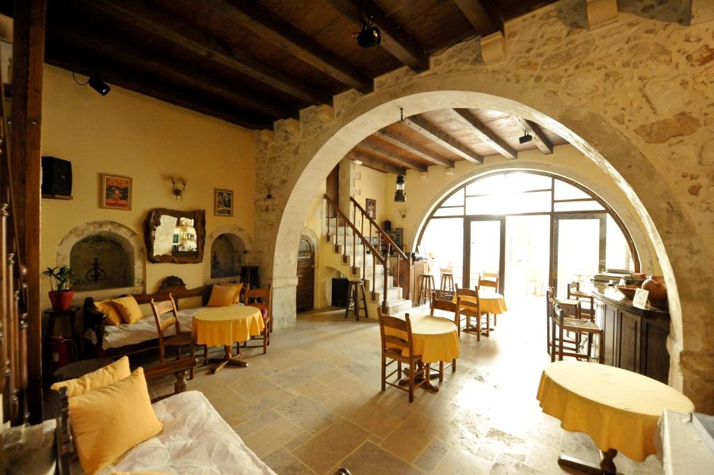 a living room with an archway and tables and chairs at Hotel Byzantine in Rethymno