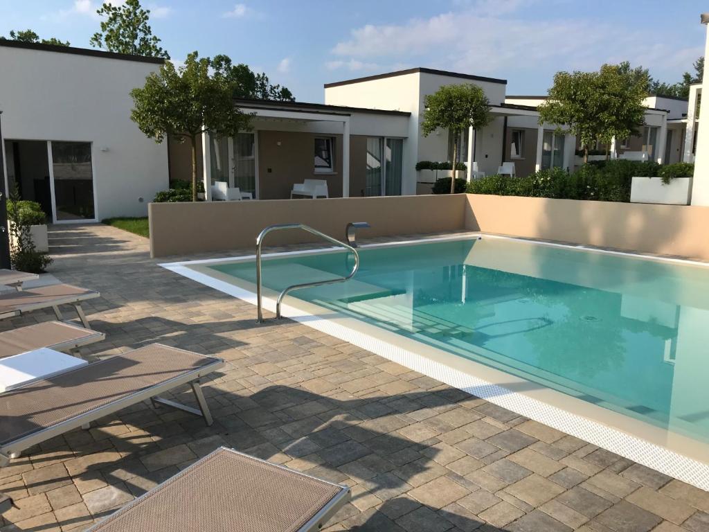 a swimming pool in front of a house at Aurora ApartHotel in Peschiera del Garda