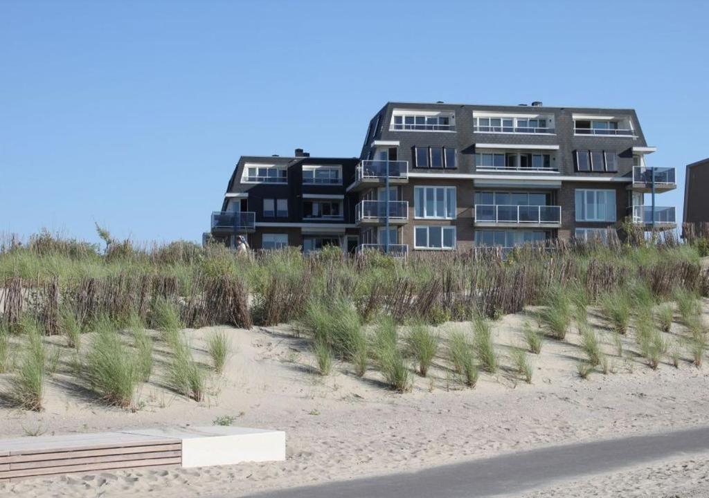 a building on the beach next to a sandy beach at Terminated in Cadzand