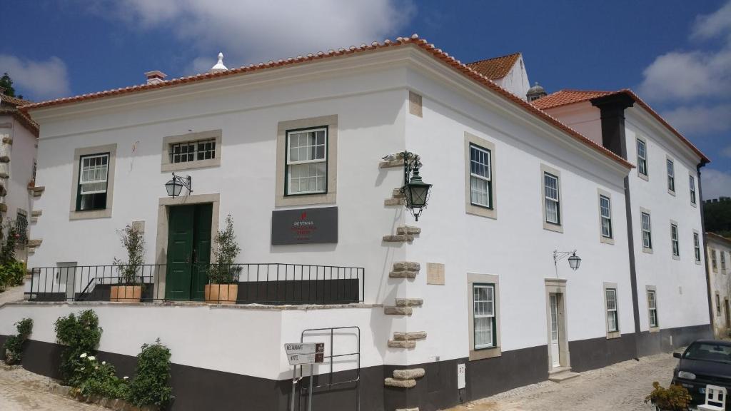 a white building with a green door at Pousada Vila Óbidos in Óbidos