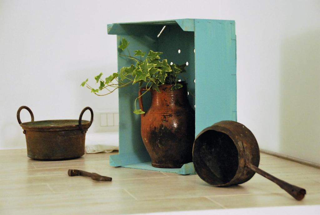 a vase and a potted plant sitting on a floor at Iannet & Co. in Locorotondo
