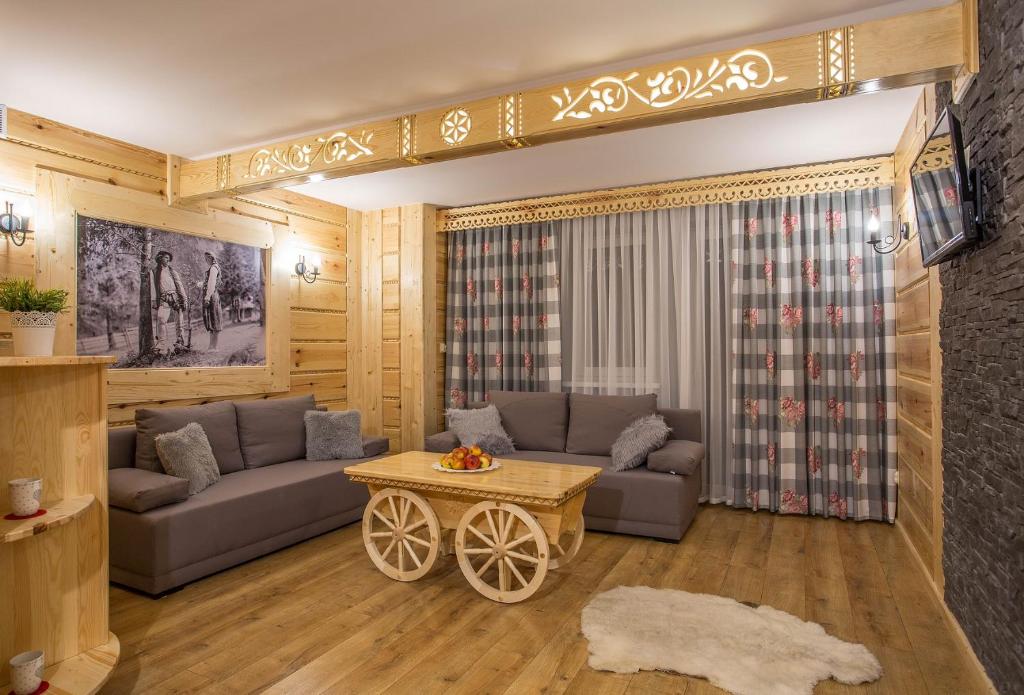- un salon avec un canapé et une table dans l'établissement Apartamenty u Grażyny, à Murzasichle