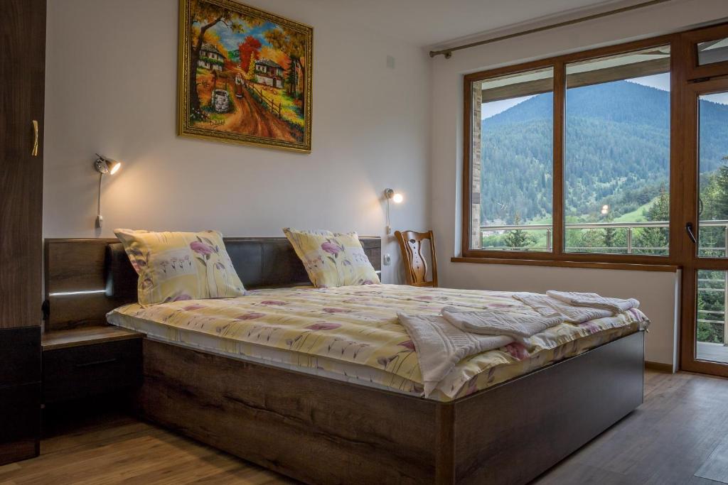 a bedroom with a large bed with a large window at Guest House Milka in Yagodina