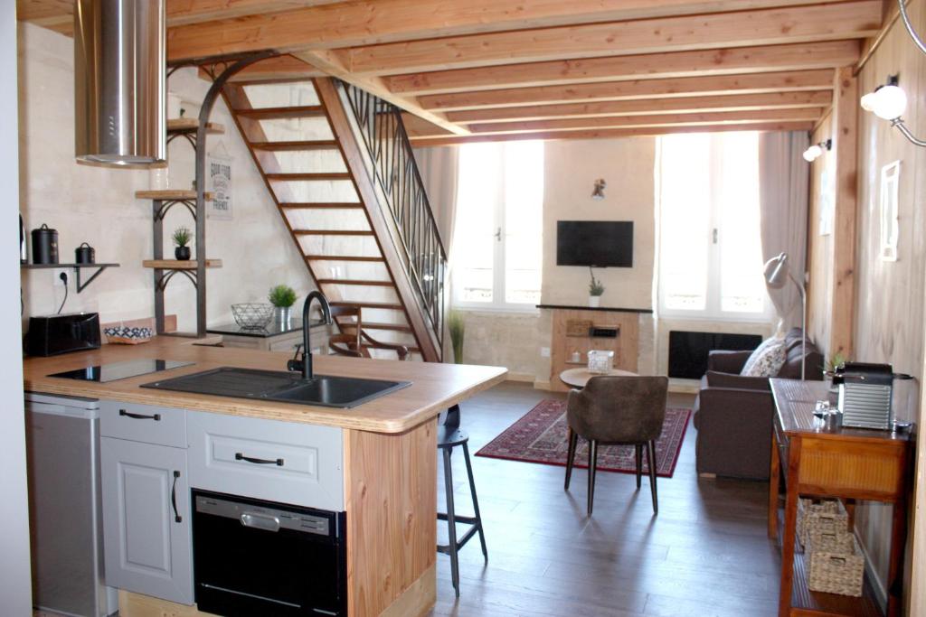 a kitchen with a sink and a living room at Le Latour, Centre-ville - Parking Gratuit in Bordeaux