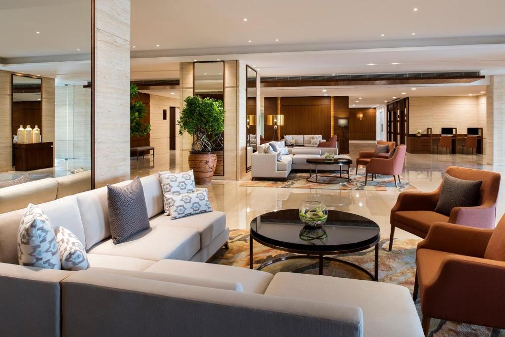 un soggiorno con divani bianchi e tavolo di Fraser Suites Muscat a Mascate