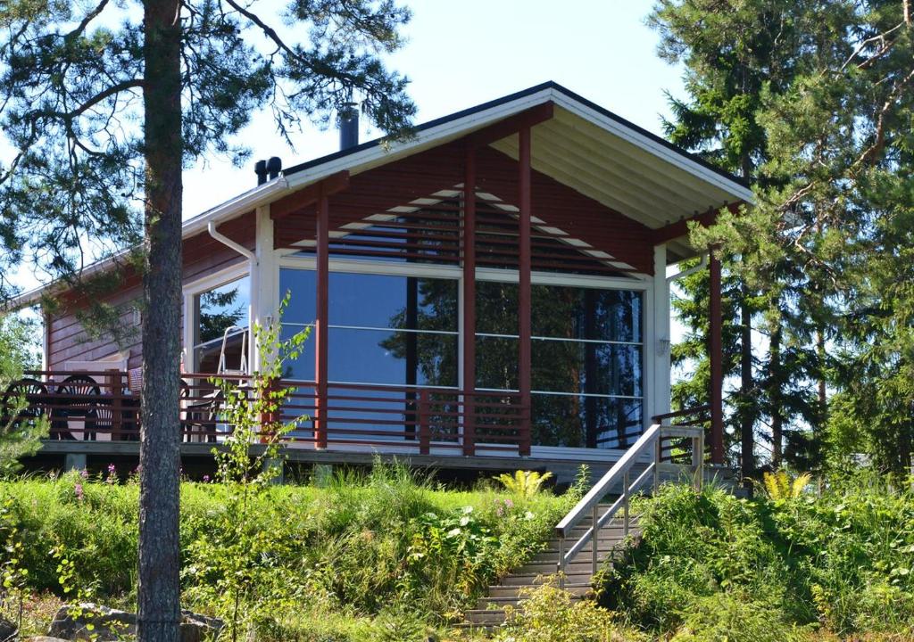 een klein huis met een afgeschermde veranda bij Tiiringolf Cottages in Nilsiä