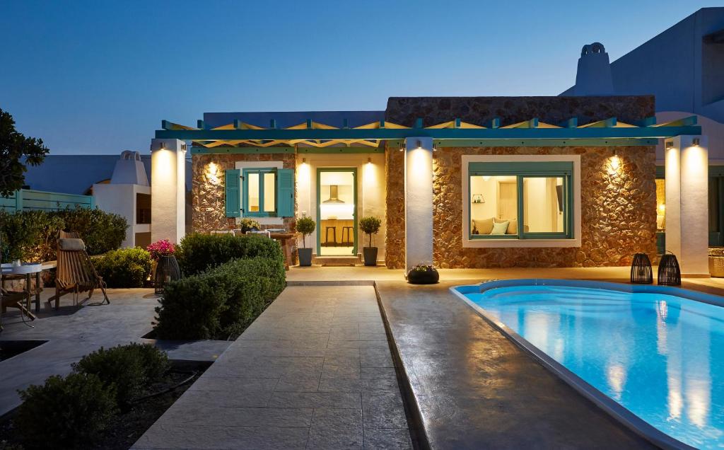 a house with a swimming pool in front of a house at Almyriki Beach Villa in Monolithos