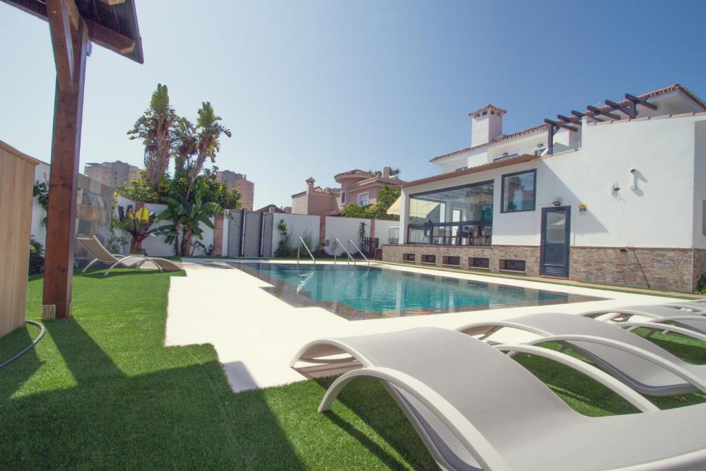 a villa with a swimming pool and a house at Pixel in Torremolinos