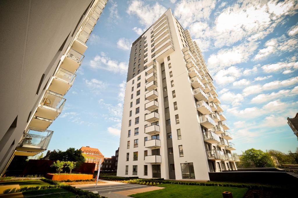 a tall white apartment building on a street at Grand Apartments - Bastion Wałowa in Gdańsk