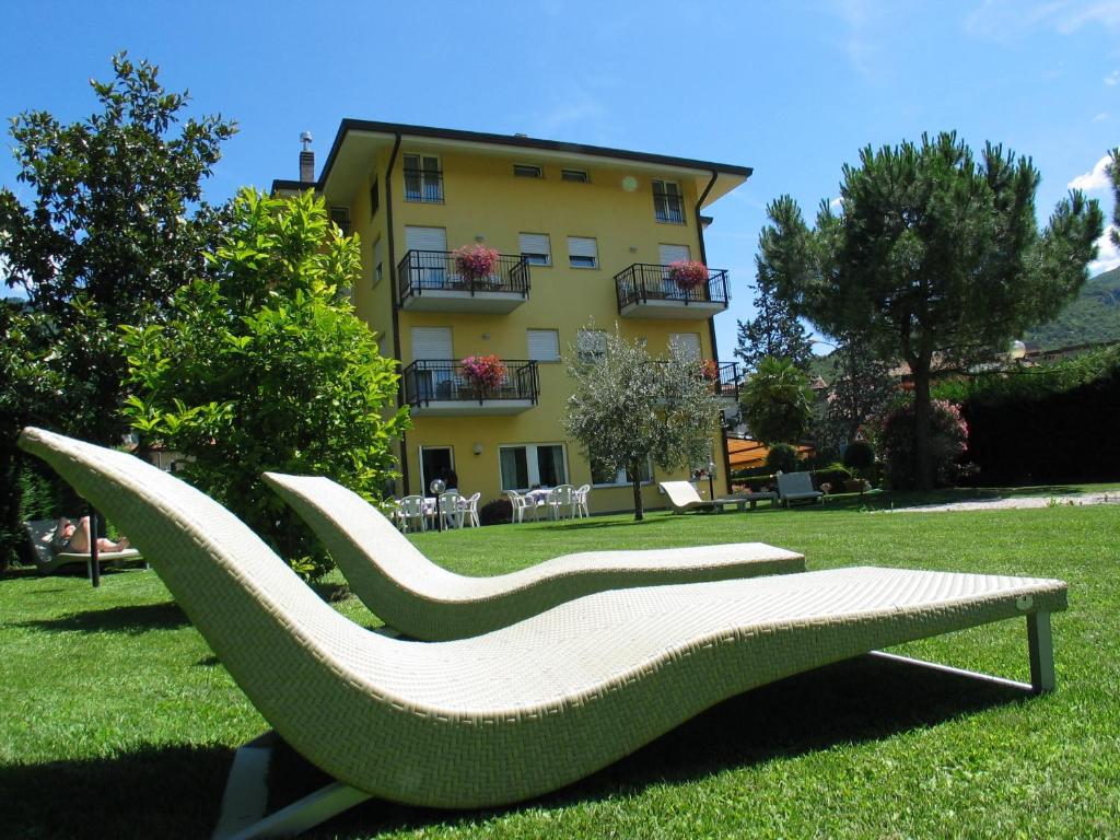 una panchina nell'erba di fronte a un edificio di Hotel Toresela Bike am Gardasee a Torbole