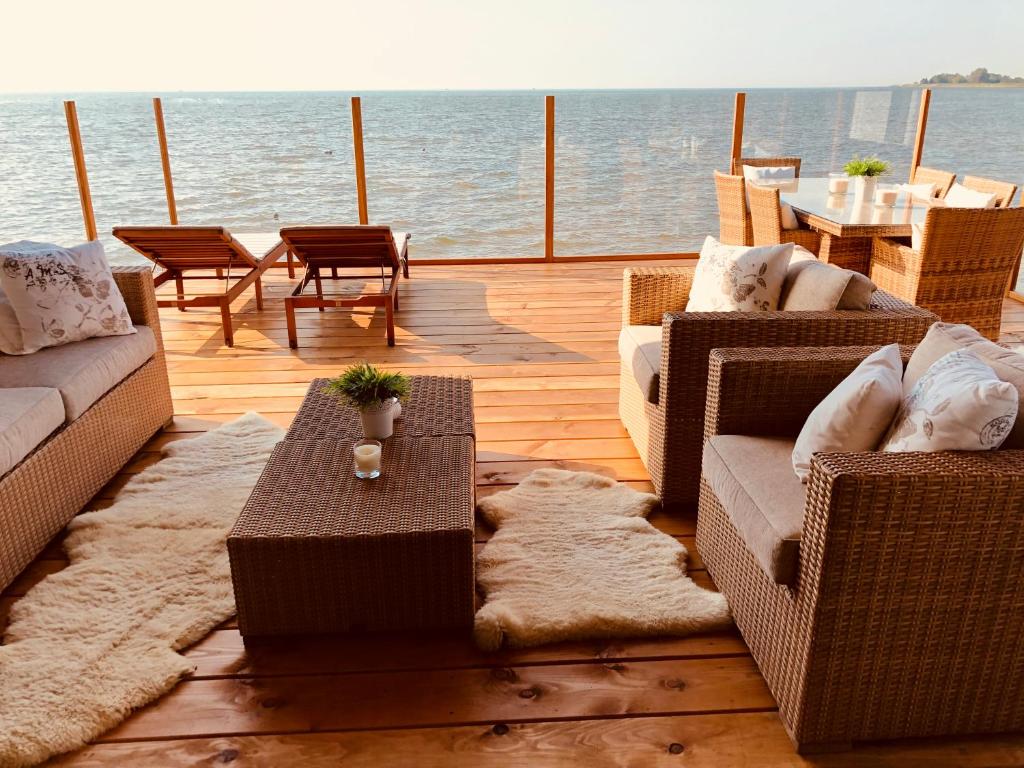 een terras met banken en een tafel op een jacht bij Vakantie Villa Markermeer in Bovenkarspel