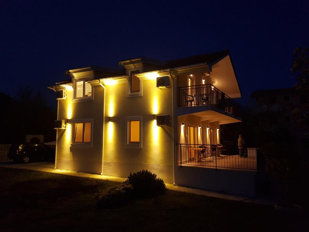 a house with lights on the side of it at night at Villa Rolla in Tivat