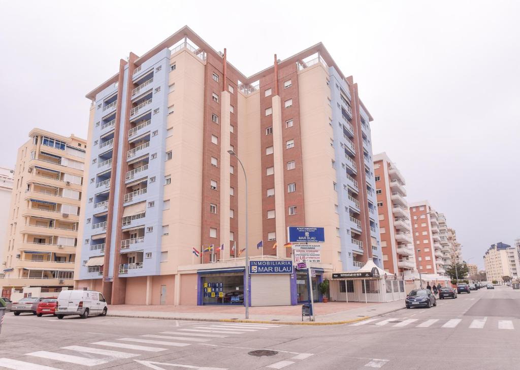 un grand bâtiment au coin d'une rue dans l'établissement Apartamentos Marblau Peredamar-Julio y Agosto SOLO FAMILIAS, à Gandía