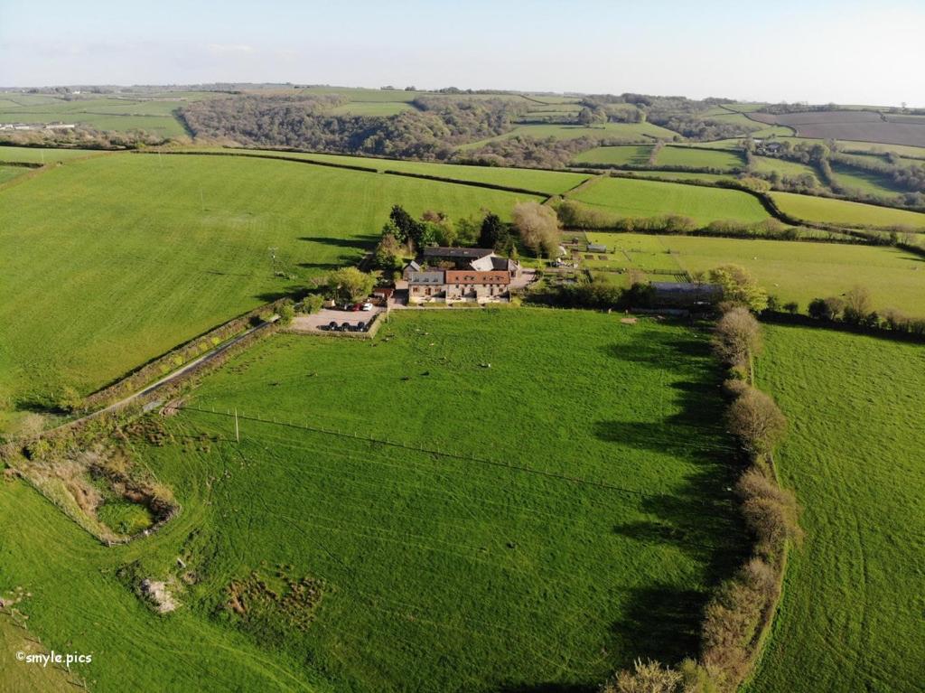 an aerial view of a house in a green field at East Trayne Holiday Cottages in South Molton
