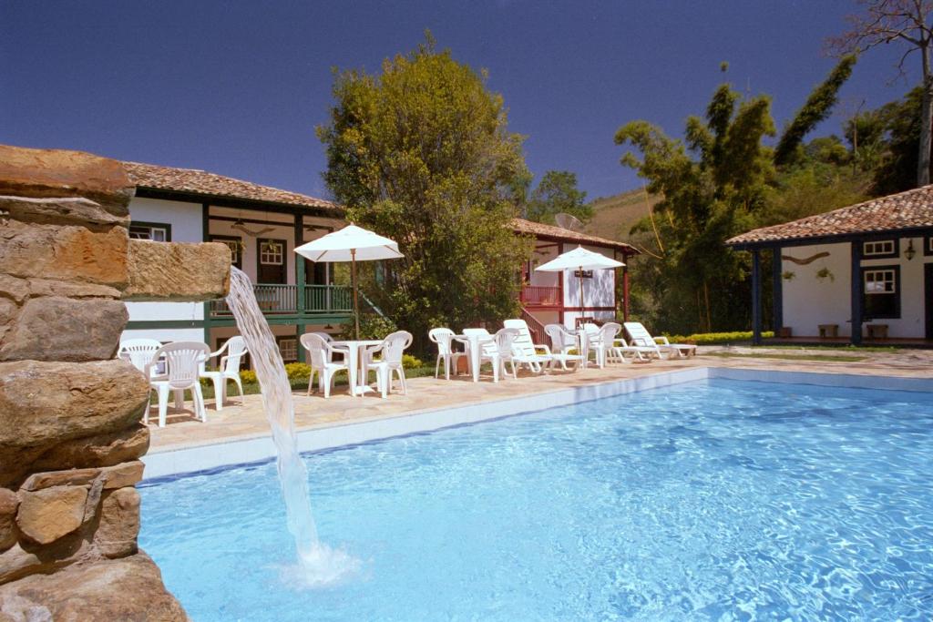 uma piscina com uma fonte de água em frente a uma casa em Hotel Solar dos Montes em Santana dos Montes