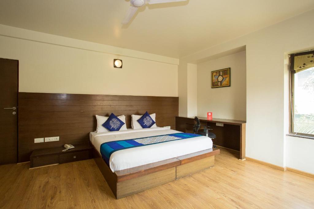 a bedroom with a large bed with blue pillows at Corporate Stay in Pune