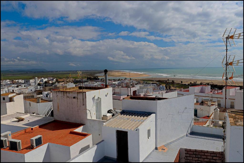 コニル・デ・ラ・フロンテーラにあるApartamento Baluarte IIIの白い建物と海の景色を望む