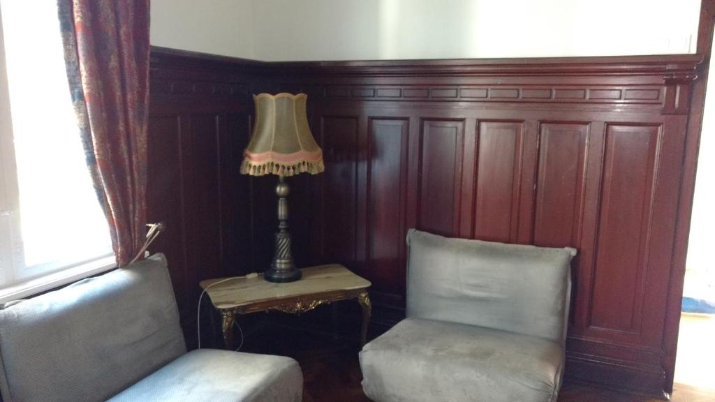 - un salon avec deux chaises et une lampe dans l'établissement Peldu apartments, à Liepāja