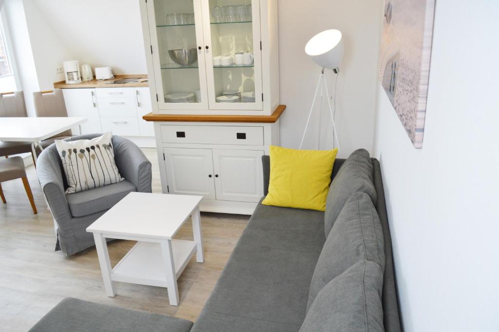 uma sala de estar com um sofá e uma mesa em Dünenmeer em Juist