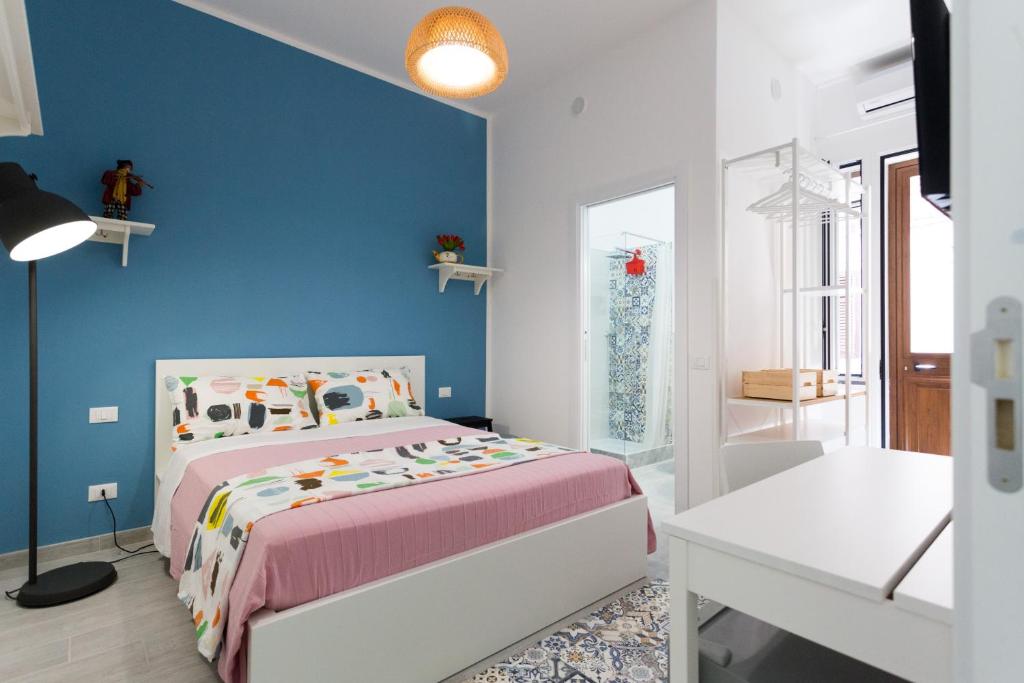 1 dormitorio con cama y pared azul en dallo Zio Totò, en Palermo