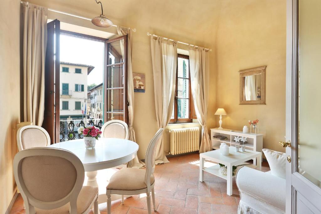 comedor con mesa, sillas y ventana en Tuscania Apartments, en Santa Croce sull'Arno