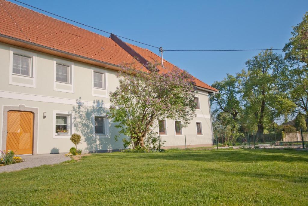 Biały dom z czerwonym dachem i dziedzińcem w obiekcie Landhaus Essl w mieście Dietach