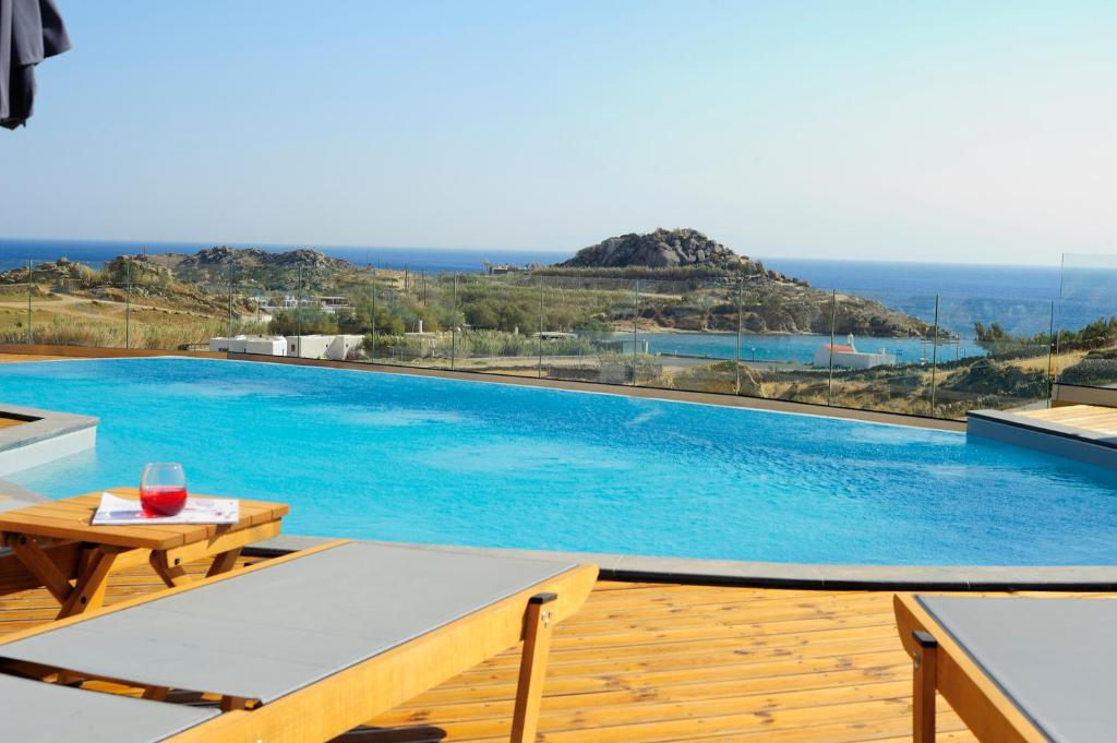 a pool with a table and a glass of wine at Almyra Guest Houses in Paraga