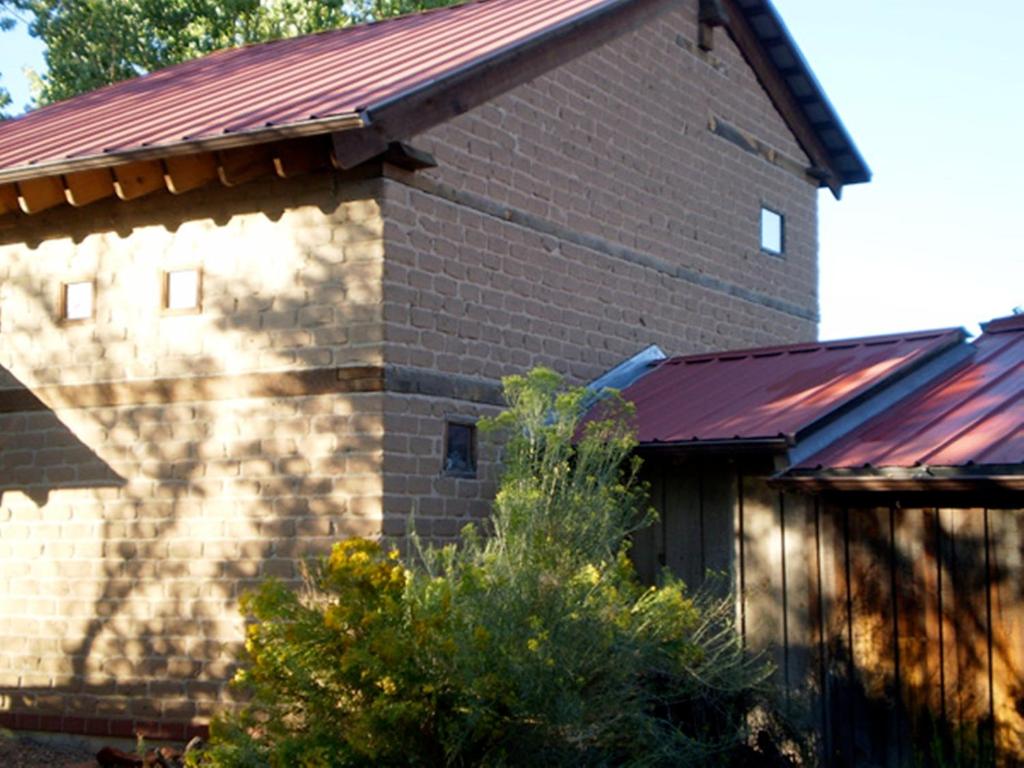 un edificio de ladrillo con techo rojo en Silver River Adobe Inn Bed and Breakfast, en Farmington