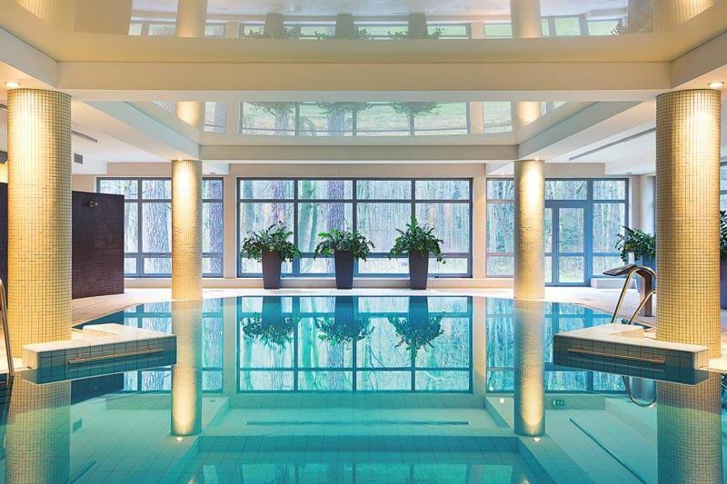 duży basen w dużym budynku w obiekcie Hotel Nowy Dwór Elizy blisko Sky Bridge w mieście Długopole-Zdrój