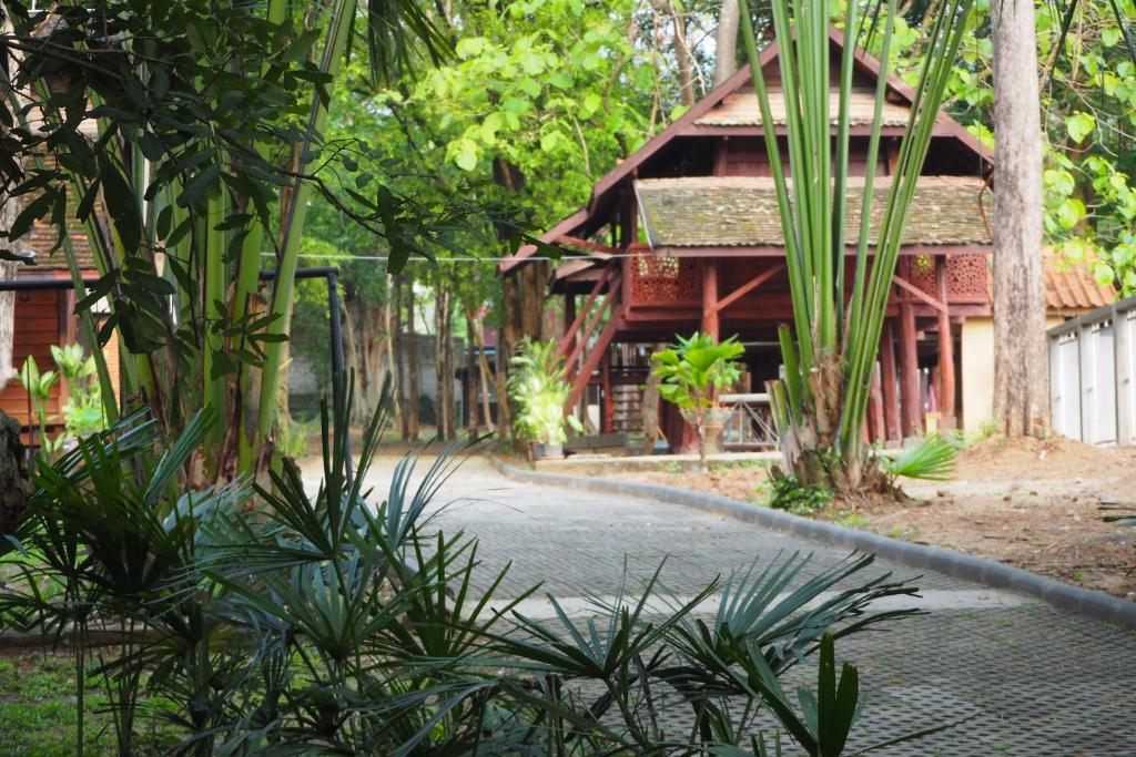a walkway in front of a house with trees at Insight Hostel in Chiang Mai