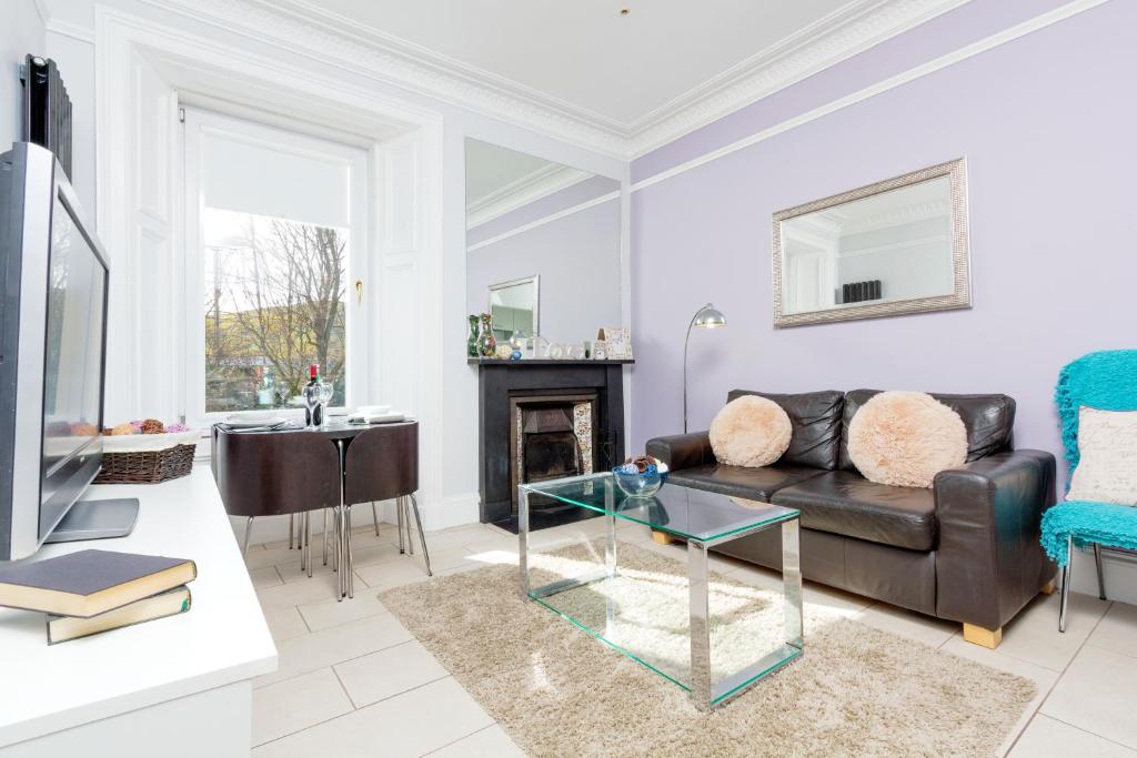 een woonkamer met een bank en een tafel bij Edinburgh Near Centre Luxury Apartment in Edinburgh