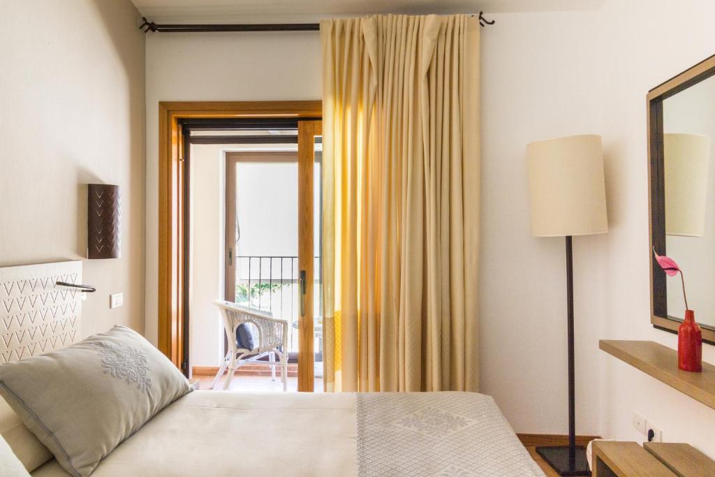 a bedroom with a bed and a sliding glass door at Hotel Aquadulci in Chia