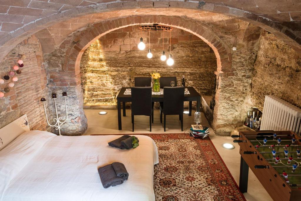 a room with a bed and a dining room with a table at La Cantina di Bea e Bella in Casciana Terme