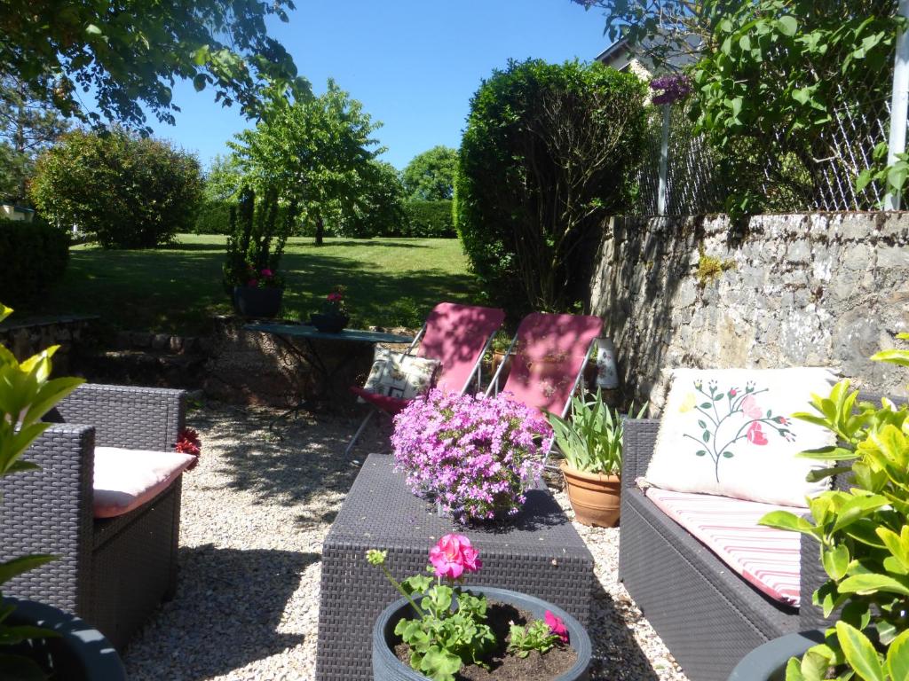 ロデーズにあるChambre d'Hôtes Le Tilleul de Canacのソファと花のテーブルが置かれた庭園
