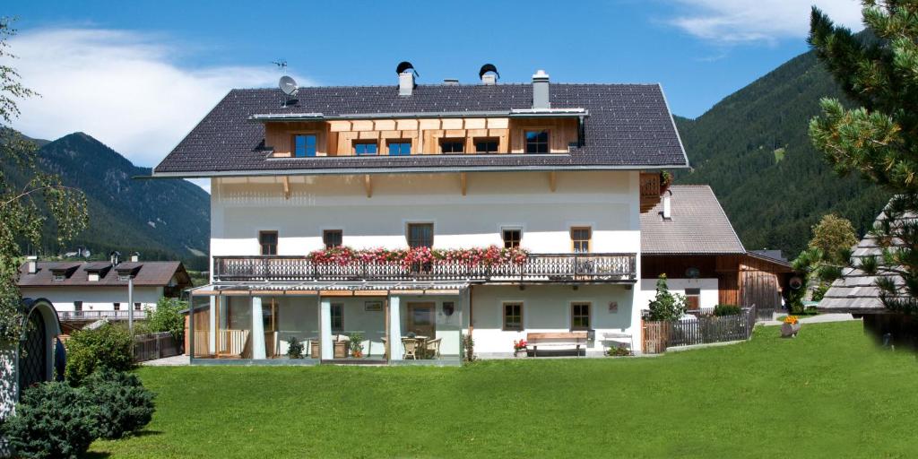 a large white house with a porch and balcony at Faltnerhof in Valle Di Casies