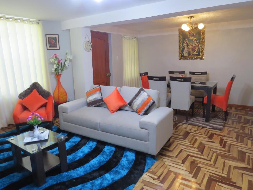 a living room with a couch and a dining room at Apartamento Familiar QUEWE in Cusco