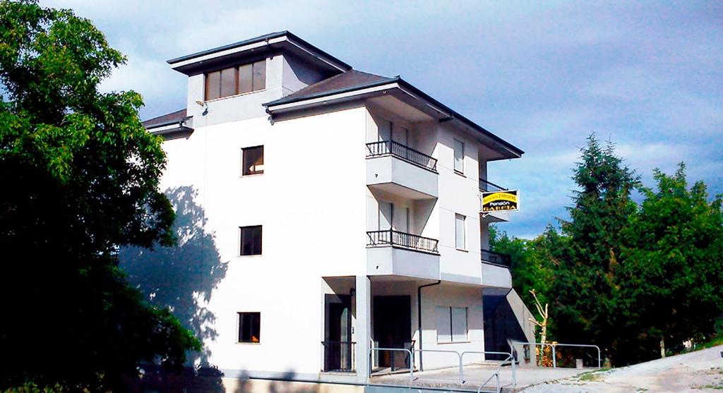 un edificio blanco con balcón en la parte superior en Pensión Garcia en Tríacastela