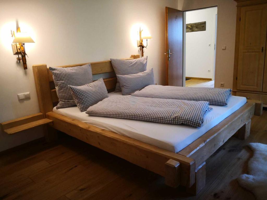a bed with four pillows on it in a room at Ferienhaus Badersee in Grainau