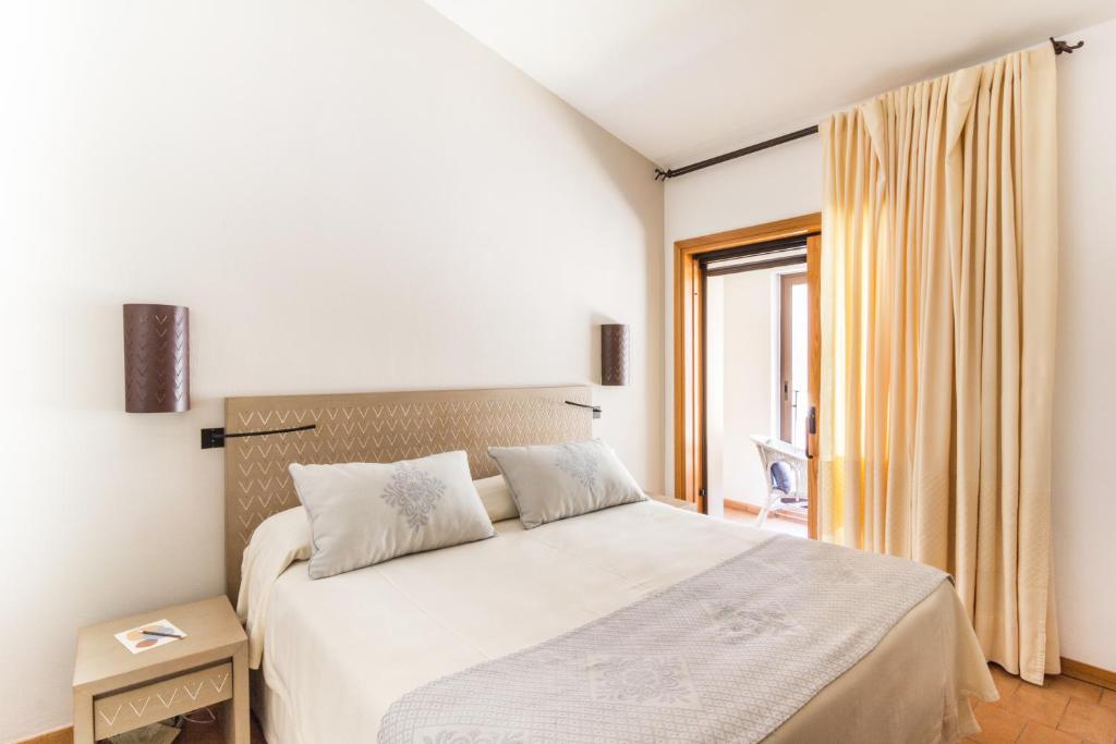 a bedroom with a large bed and a window at Hotel Aquadulci in Chia