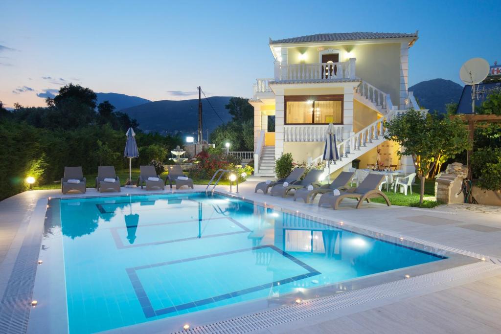 a villa with a swimming pool in front of a house at Villa Alonia in Skala